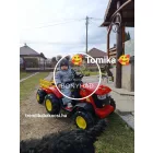 Gyermek vezeti a piros traktort a kertben