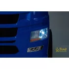 Kék Scania elektromos kamion LED-es első lámpákkal világítva