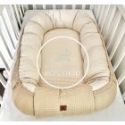 Mogyoró-bMogyoró-bézs waffle babafészek oldalnézetből – prémium, kézzel készült kivitelézs waffle babafészek kiságyban – biztonságos és kényelmes pihenőhely babáknak